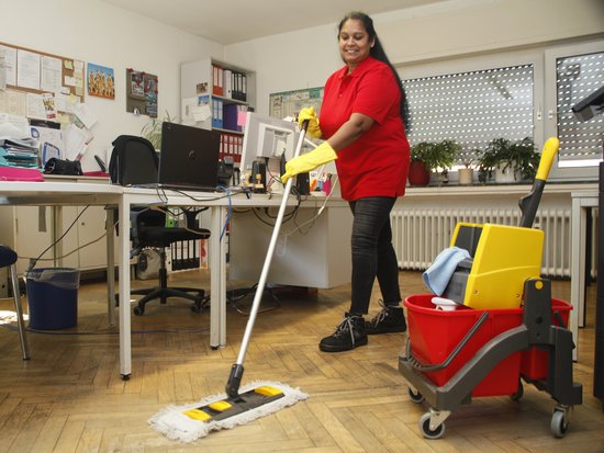 eine Frau wischt ein Büro