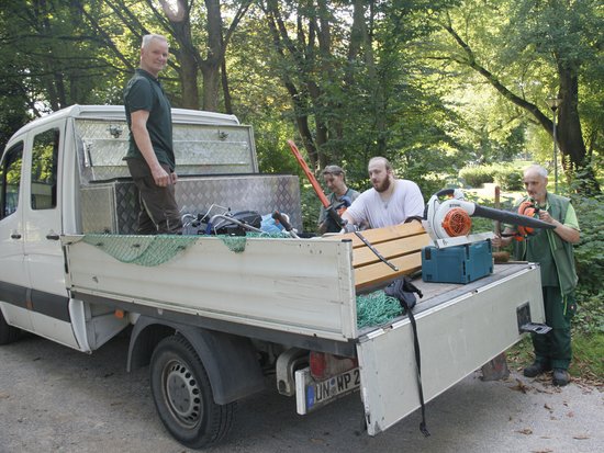 Menschen beladen einen Pritschen LKW