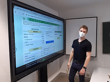 Mann vor großem Monitor