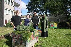 4 Personen stehen hinter einem Hochbeet