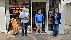 3 Männer vor Laden